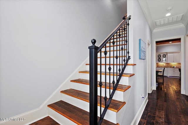 staircase with crown molding and wood-type flooring