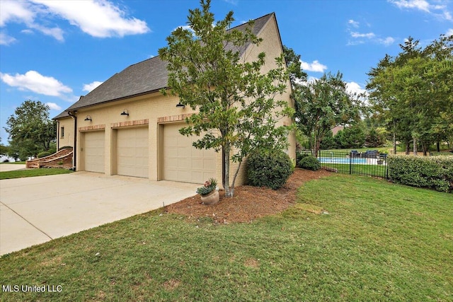 view of side of property with a yard and a garage