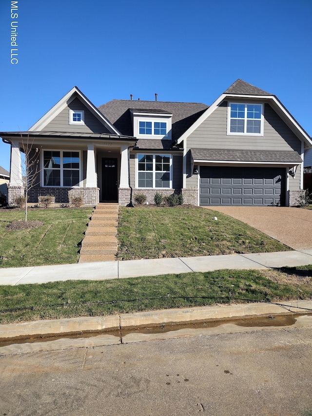 craftsman house featuring a garage and a front lawn