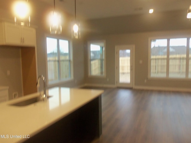 kitchen featuring white cabinetry, sink, dark hardwood / wood-style flooring, and decorative light fixtures