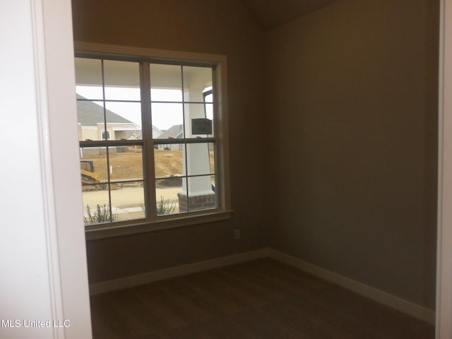 unfurnished room featuring vaulted ceiling and dark hardwood / wood-style floors