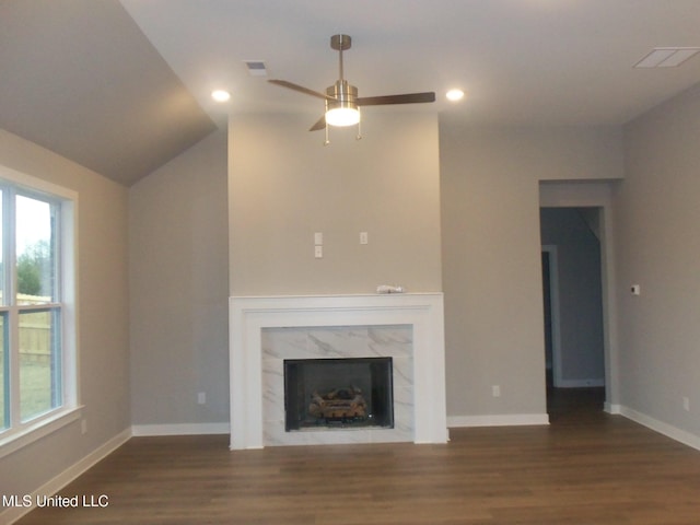 unfurnished living room with dark hardwood / wood-style floors, plenty of natural light, and a premium fireplace