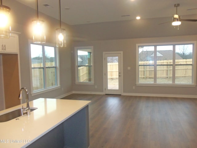 kitchen with hanging light fixtures, ceiling fan, sink, and dark hardwood / wood-style flooring