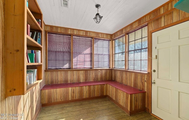 interior space featuring hardwood / wood-style floors and wooden walls