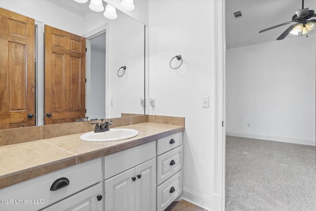 bathroom with crown molding, ceiling fan, and vanity