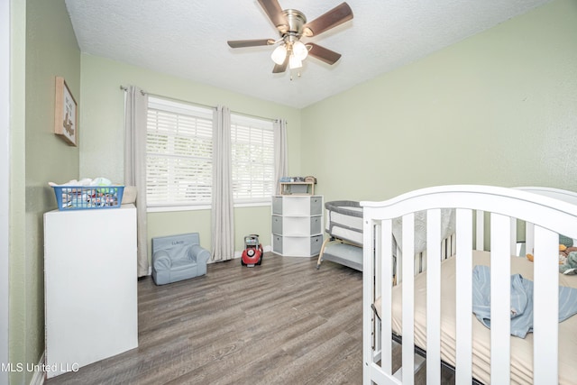 bedroom with a textured ceiling, a ceiling fan, and wood finished floors