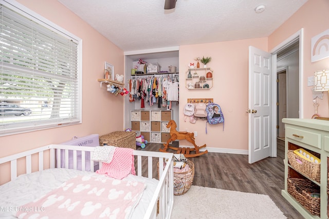 bedroom with a ceiling fan, wood finished floors, and baseboards