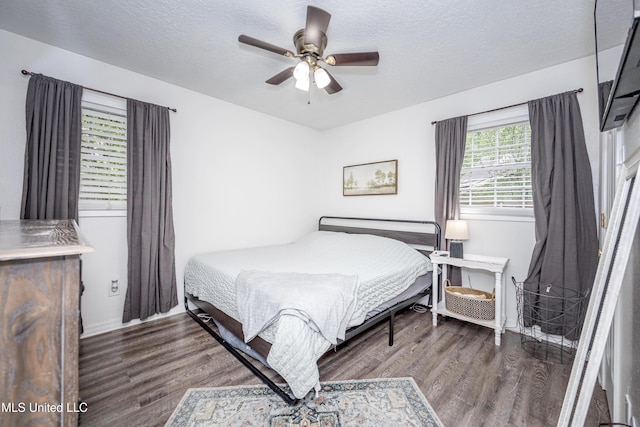 bedroom with a textured ceiling, baseboards, a ceiling fan, and wood finished floors