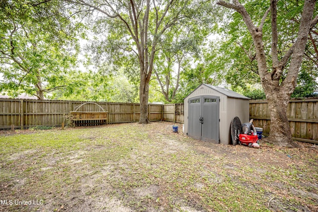 view of yard with an outbuilding, a fenced backyard, and a shed