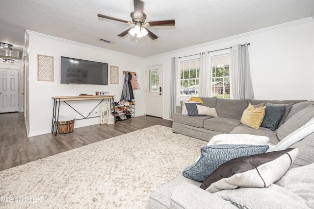 living room with crown molding, visible vents, wood finished floors, and a ceiling fan