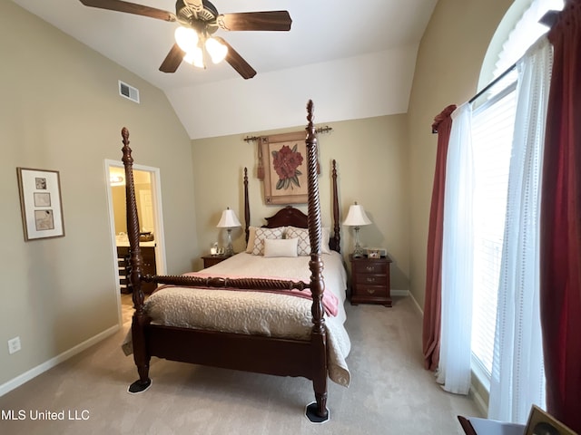 bedroom featuring ensuite bathroom, lofted ceiling, light colored carpet, and ceiling fan