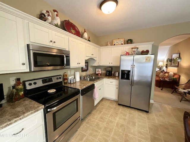 kitchen featuring stainless steel appliances, white cabinetry, and sink