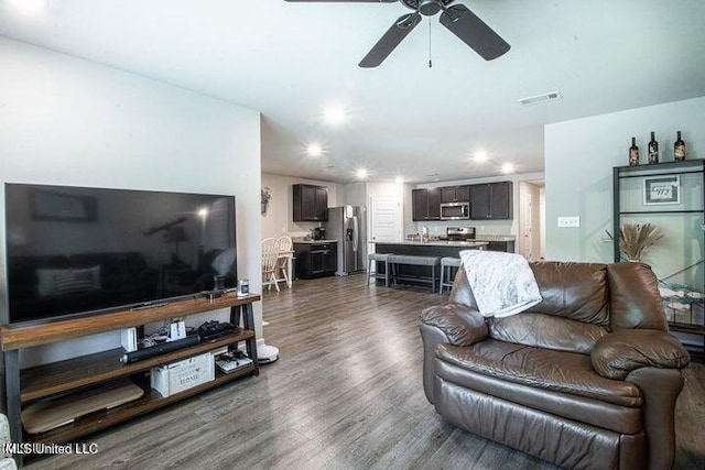 living room with dark hardwood / wood-style flooring and ceiling fan