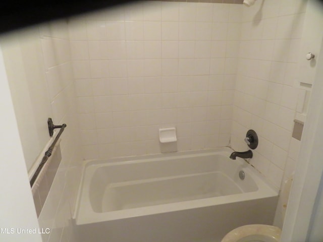 bathroom featuring toilet and tiled shower / bath combo