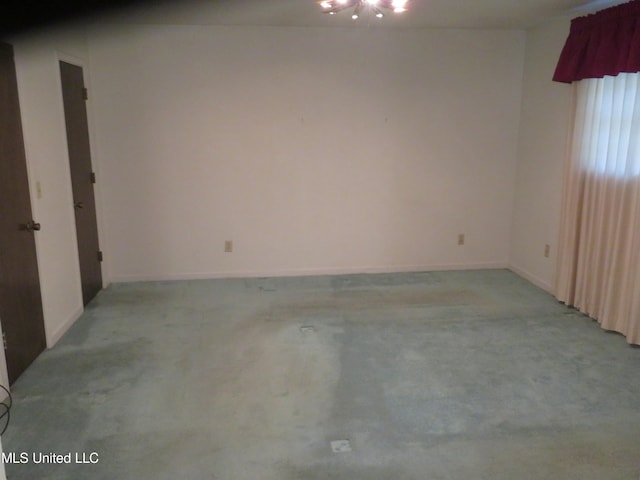 empty room featuring light carpet and an inviting chandelier