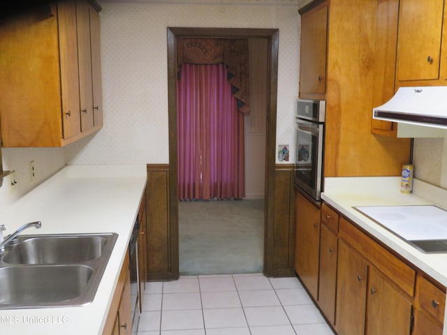 kitchen featuring cooktop, sink, stainless steel oven, range hood, and light tile patterned floors