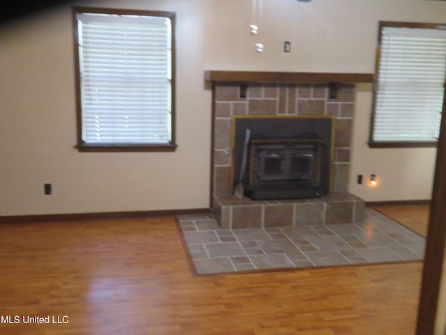 unfurnished living room with hardwood / wood-style floors and a wood stove