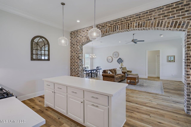 953 Glenwild Cir, Canton, MS 39046 - kitchen featuring crown molding, a chandelier, a kitchen island, a ceiling fan, and light countertops