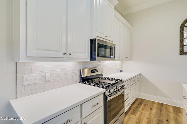 953 Glenwild Cir, Canton, MS 39046 - kitchen featuring stainless steel appliances, white cabinets, light wood-style flooring, backsplash, and crown molding
