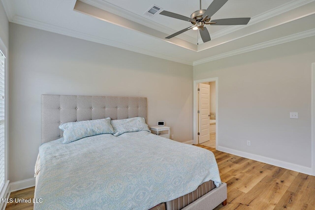 953 Glenwild Cir, Canton, MS 39046 - bedroom featuring a raised ceiling, light wood-type flooring, ornamental molding, ensuite bath, and a ceiling fan