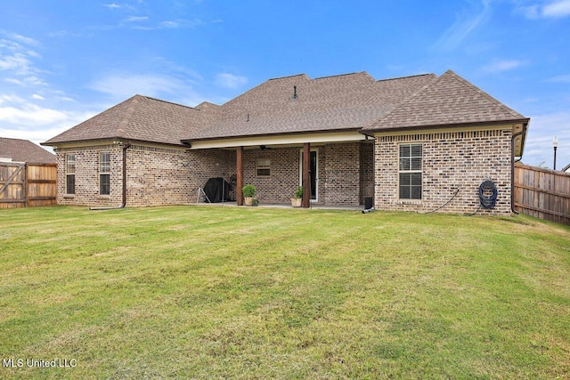 953 Glenwild Cir, Canton, MS 39046 - back of property featuring brick siding, a fenced backyard, and roof with shingles