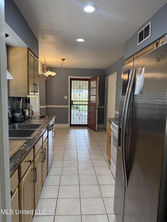 8528 E Cedar Cir, Southaven, MS 38671 - kitchen featuring stainless steel appliances, dark countertops, a textured ceiling, a chandelier, and light tile patterned flooring