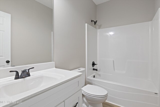 full bathroom featuring hardwood / wood-style floors, vanity, shower / bathtub combination, and toilet