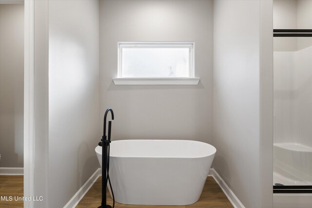 bathroom featuring hardwood / wood-style flooring and separate shower and tub