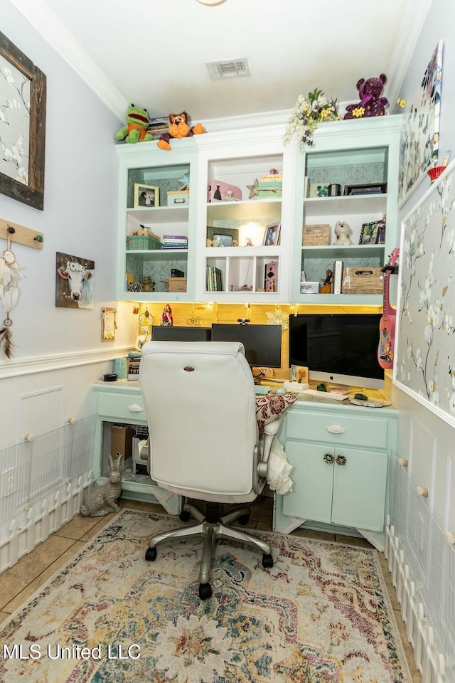 home office featuring light tile patterned flooring, visible vents, ornamental molding, and wainscoting