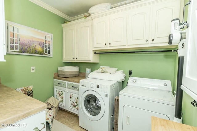 laundry area with ornamental molding, cabinet space, washing machine and clothes dryer, and light tile patterned floors