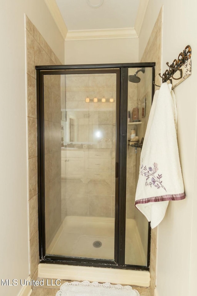 bathroom with ornamental molding and a stall shower