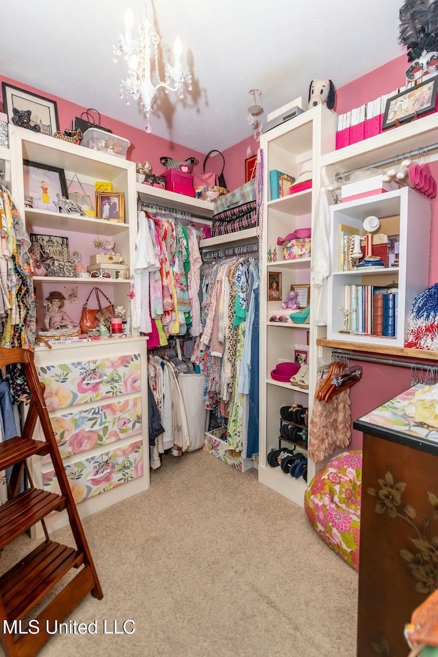 spacious closet featuring carpet flooring and an inviting chandelier