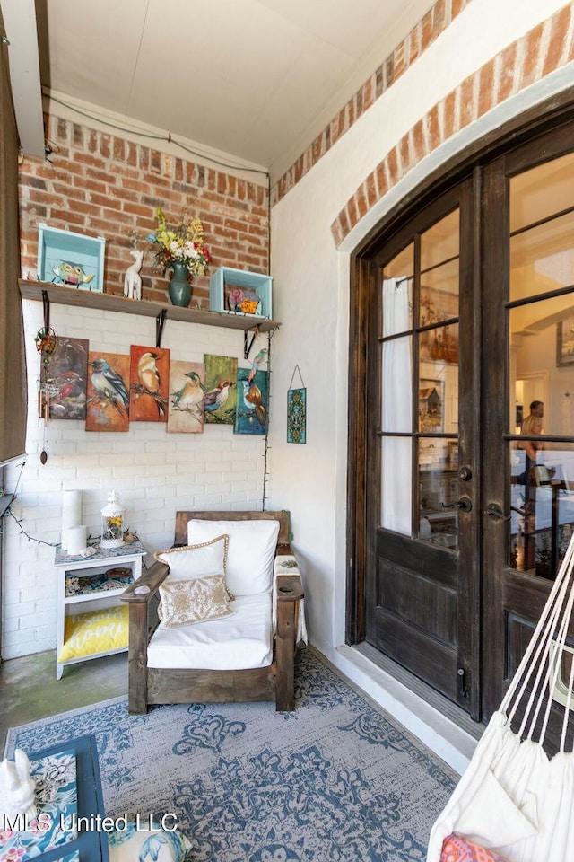 interior space with brick wall and french doors