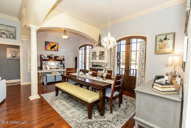 dining room featuring ornamental molding, arched walkways, dark wood finished floors, and ornate columns