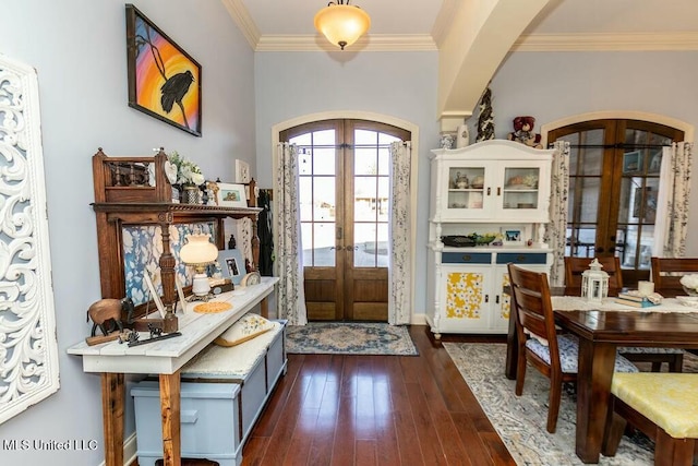 foyer with dark wood-style floors, arched walkways, french doors, and ornamental molding