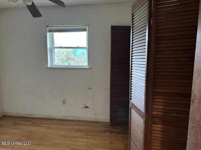 empty room with ceiling fan and light hardwood / wood-style floors