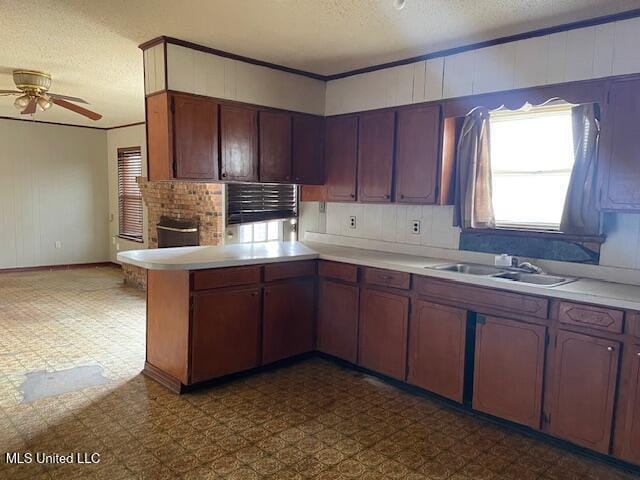 kitchen featuring sink, a textured ceiling, kitchen peninsula, and ceiling fan