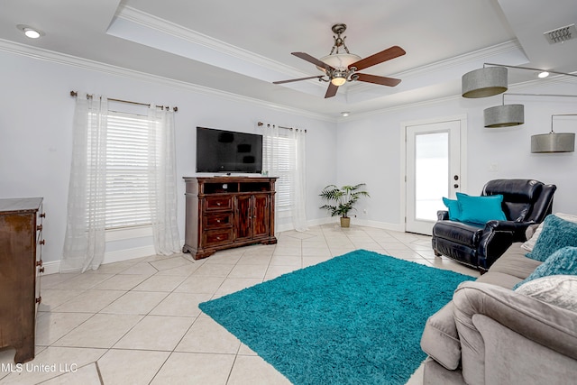 tiled living room featuring crown molding, a raised ceiling, and ceiling fan