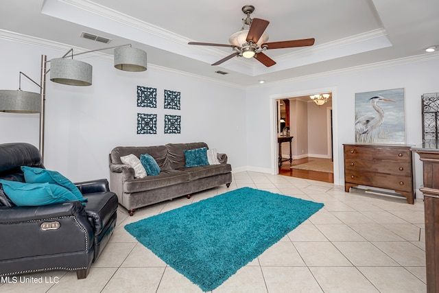 living room with crown molding, ceiling fan, light tile patterned floors, and a raised ceiling