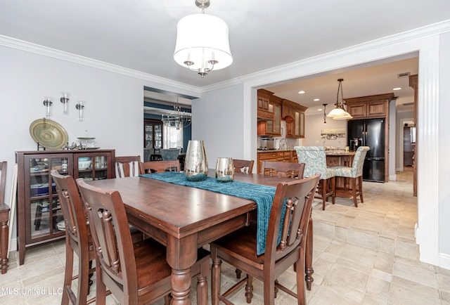 dining space with ornamental molding and an inviting chandelier