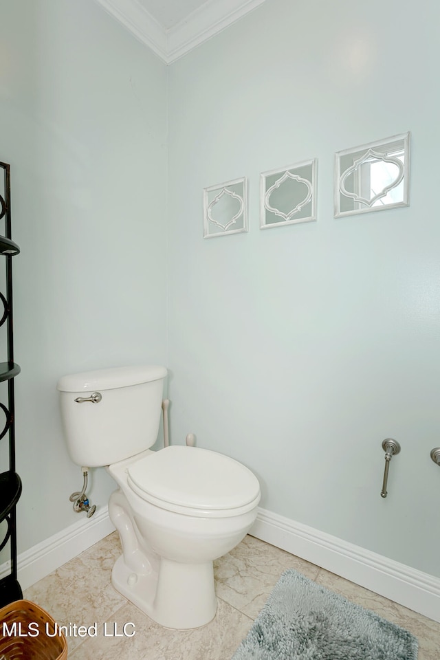 bathroom featuring crown molding and toilet