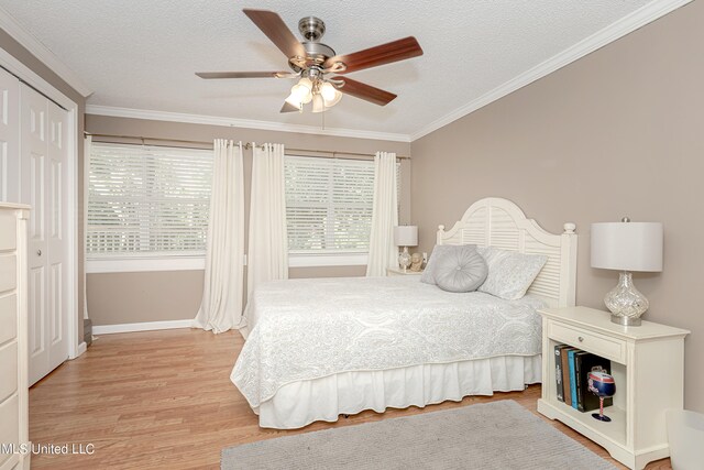 bedroom with light hardwood / wood-style floors, crown molding, a textured ceiling, and ceiling fan