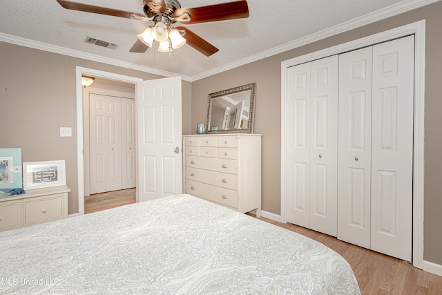 bedroom with ceiling fan, ornamental molding, a textured ceiling, and light hardwood / wood-style floors