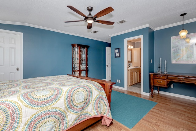 bedroom featuring ceiling fan, a textured ceiling, connected bathroom, light wood-type flooring, and crown molding