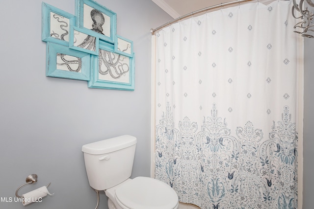 bathroom with toilet, ornamental molding, and a shower with curtain