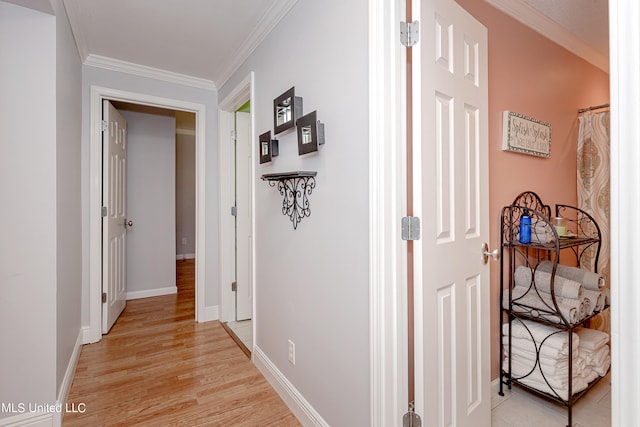 hall with light hardwood / wood-style floors and ornamental molding