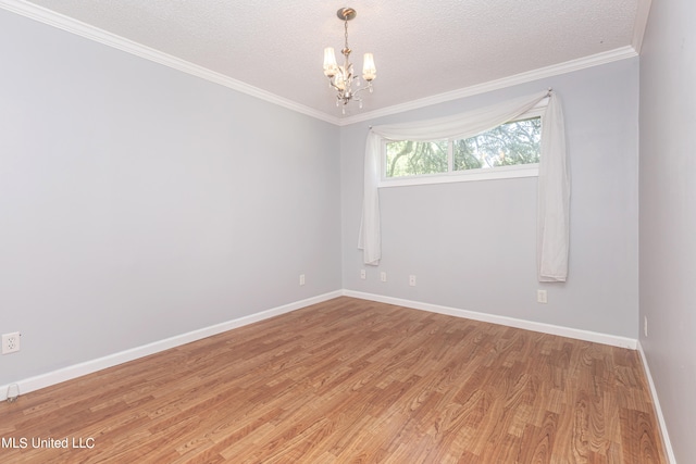 spare room with crown molding, a textured ceiling, a chandelier, and hardwood / wood-style floors