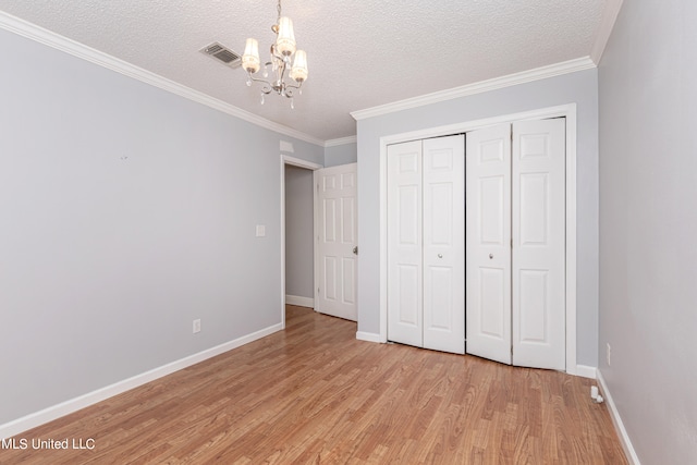 unfurnished bedroom featuring ornamental molding, a closet, and light wood-type flooring