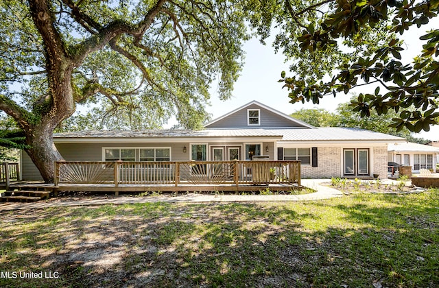 rear view of property with a wooden deck and a yard