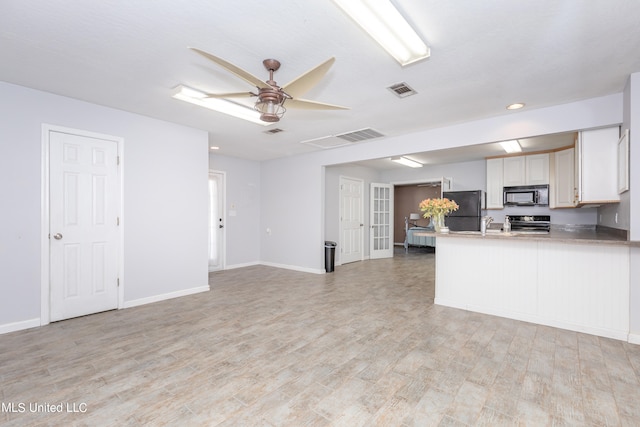 kitchen featuring kitchen peninsula, ceiling fan, white cabinetry, black appliances, and light hardwood / wood-style floors